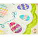 Close up of table topper edge showing a bright green border and decorated easter eggs on a cream background with tiny multicolored bunnies all over and a plaid round center