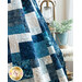 Close up of blue and cream batik quilt with asymmetrical squares draped over 