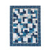 Hanging quilt filled with asymmetrical blocks in blue and cream batiks isolated on a white background
