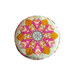 Image of a round yellow and pink pincushion quilted in an intricate flower shape on a white background