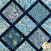 A quilt featuring blue fabric with sea life patterns, including turtles, jellyfish, and starfish.