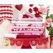 pink, red, and white fabrics with hearts and gnomes stacked on a red pedestal with roses behind