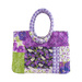 A tote bag made with purple and green floral fabrics isolated on a white background