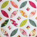 Close up image of the local honey orange blossom throw quilt, consisting of a white background with 5 overlapping circular designs made up of petal and diamond shapes, each made from different floral fabrics in pink, yellow, and green 