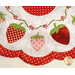 Close up of June table topper showing white and red fabric and floral embroidery detail with strawberry shaped applique