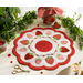 A white countertop with foliage and a houseplant in the background with a white and red strawberry themed table topper with notions and a jar of strawberries in the background.