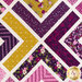 Close up of quilt blocks made up of intersecting white lines and purple and yellow floral fabrics