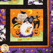 Close up of a corner quilt block depicting a gnome with Halloween decor, a black cat, and jack-o-lanterns with a sign that reads 