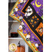 Close up of quilt blocks made with Halloween fabrics with gnomes and jack-o-lanterns draped in front of a white shelf covered in Halloween decor.
