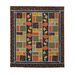 A large, autumn themed quilt in green, orange, black, and yellow with pumpkin and oak leaf applique details isolated on a white background