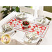 A top down image of a white table with four place settings with white plates and matching strawberry themed napkins in silver napkin rings and a red and white table runner in the center with a fabric basket filled with fabric strawberries.