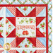 Close up of one quadrant of the quilt showing a sawtooth star in red fabric with strawberry themed blue and cream fabrics