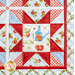 Close up of one quadrant of the quilt showing a sawtooth star in red fabric with strawberry themed blue and cream fabrics