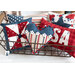 A white countertop and white paneled wall with a collection of small patriotic themed pillows in a wire basket