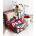 A small wire basket full of patriotic mini pillows propped up by books with a metal pitcher full of flowers and a 