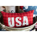close up image of one of the mini pillows in a metal tub featuring red plaid and the white letters 