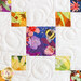 Close up of a block featuring squares arranged diagonally made with floral and bee themed fabrics on a white background