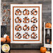 A photo of a pumpkin and Halloween themed quilt hanging on a gray paneled wall with halloween decor all around