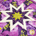 Close up of hot pad detail for May, featuring bold purple and bright green floral fabrics.