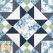 Close up of a geometric block at the center of the quilt made with navy, light blue, cream and green floral fabrics
