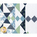 Angled photo of a geometric pattern at the center and side of the quilt made with navy, light blue, cream and green floral fabrics