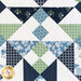 Close up of a geometric block in the quilt made with navy, light blue, cream and green floral fabrics