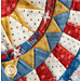 close up of patriotic quilt square made with red, white, blue, and yellow fabrics with stars and textures in a radiating pattern