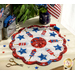 A patriotic red, white, and blue scalloped table topper with stars and fireworks