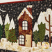close up photo of applique detail showing a wintry town with decorated pine trees