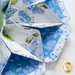 Close up of flower-shaped table topper showing folded floral fabrics in white, blue, and green