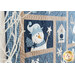 Angled photo of a blue and tan quilt with a block in focus depicting a snowman wearing a hat and scarf holding a star with a white bare tree branch in the foreground