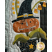 Close up of a small Halloween themed quilt applique motif of a jack-o-lantern on a stalk coming out of a cauldron wearing a witch's hat.
