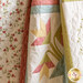 close up of a draped and gathered pastel floral quilt showing floral motifs and stitching detail