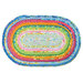 Colorful jelly roll rug with blue, pink, orange, yellow, green and white concentric circles isolated on a white background