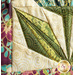 Close up image of floral quilt block, showing fabric details like metallic swirls and floral patterns