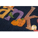 Close up of the Words in Wool November mat showing the applique detail of multicolored letters and two small pumpkins