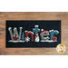 black rectangular table mat on a brown wooden countertop with the word 