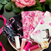 Photo of 5 breast cancer awareness fabrics in pink, white and black, all included in the pink ribbon collection, fanned out in a pink bowl with threads, flowers, and a ribbon