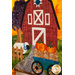 A close up photo of an autumn-themed wall hanging featuring a red barn, wagon full of pumpkins, and a sheep.