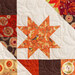Close up photo of block in autumn-themed quilt made with Forest Frolic fabrics in a geometric pattern