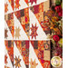 Close up, angled photo of blocks in autumn themed quilt made with Forest Frolic in a geometric pattern with autumn floral decor in the foreground