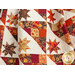 Close up photo of an autumn themed quilt, draped and made with Forest Frolic in a geometric pattern