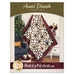 The front cover of the Aunt Dinah Throw Quilt pattern showing a finished quilt draped in front of a white paneled wall with furniture and a houseplant