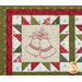 Close up of one quilt block showing fabric and stitching detail with an embroidered image of holly and bells