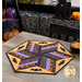 Photo of a Halloween themed table topper in the center of a gray table with halloween decor in the background and a bowl of candy corn on the table.