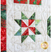 Close up photo of a quilt block featuring a quilt star made out of christmas themed batik fabrics