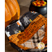 Close up photo of one Halloween-themed bowl cozy made with the Hey Bootiful fabric collection on a table with pumpkin decor and a small cauldron full of candy corn in the background