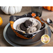 Photo of a place setting with a bowl filled with oreo ice cream and oreos inside the Hey Bootiful bowl cozy with small pumpkins in the background