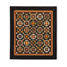 Photo of an orange, brown, and black quilt featuring traditional quilt block patterns isolated on a white background.