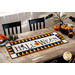 A photo of a dining table with a table runner with a candy corn border and the word 